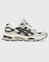 Asics Gel-NYC 2.0 sneaker zijaanzicht: witte upper, zwarte strepen, beige-zool