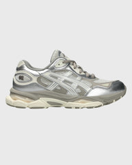 Sneaker zijaanzicht, rookgrijs bovenwerk met metallic zilveren overlays en dikke sportzool.