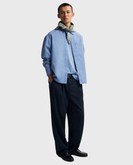 Boxy overhemd in dusty blue met puntkraag en knoopsluiting, zijdelings gedragen