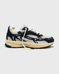 Donkerblauwe sneakers met witte bovenkant, gele veters en beige tussenzool