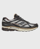 Saucony sneakers met donkergrijs bovenwerk, mesh panelen, veters en beige zool.