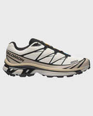 Salomon XT-6 sneaker in wit met zwarte accenten, gele veter en stevige zool.