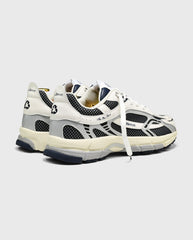 Witte sneaker met blauw-zwarte mesh, accenten en lichtgekleurde zool