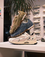 Sneakers op plank: suède zandkleur, blauw en beige met roze accenten