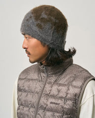 Donkere grijze beanie met spetterpatroon, gedragen over de zijkant van het hoofd