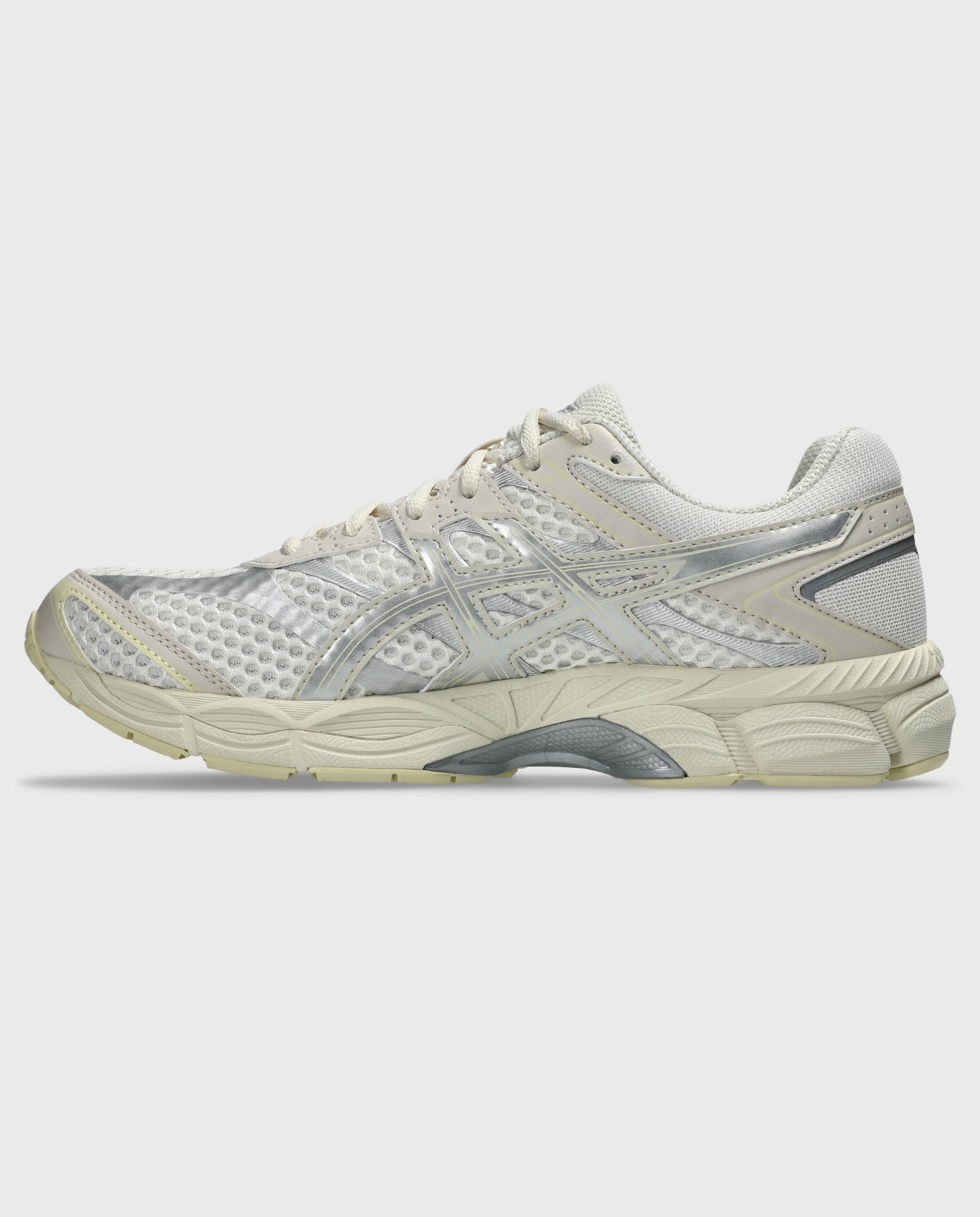 Asics hardloopschoen met crème mesh, zilveren overlays en geprofileerde zool.