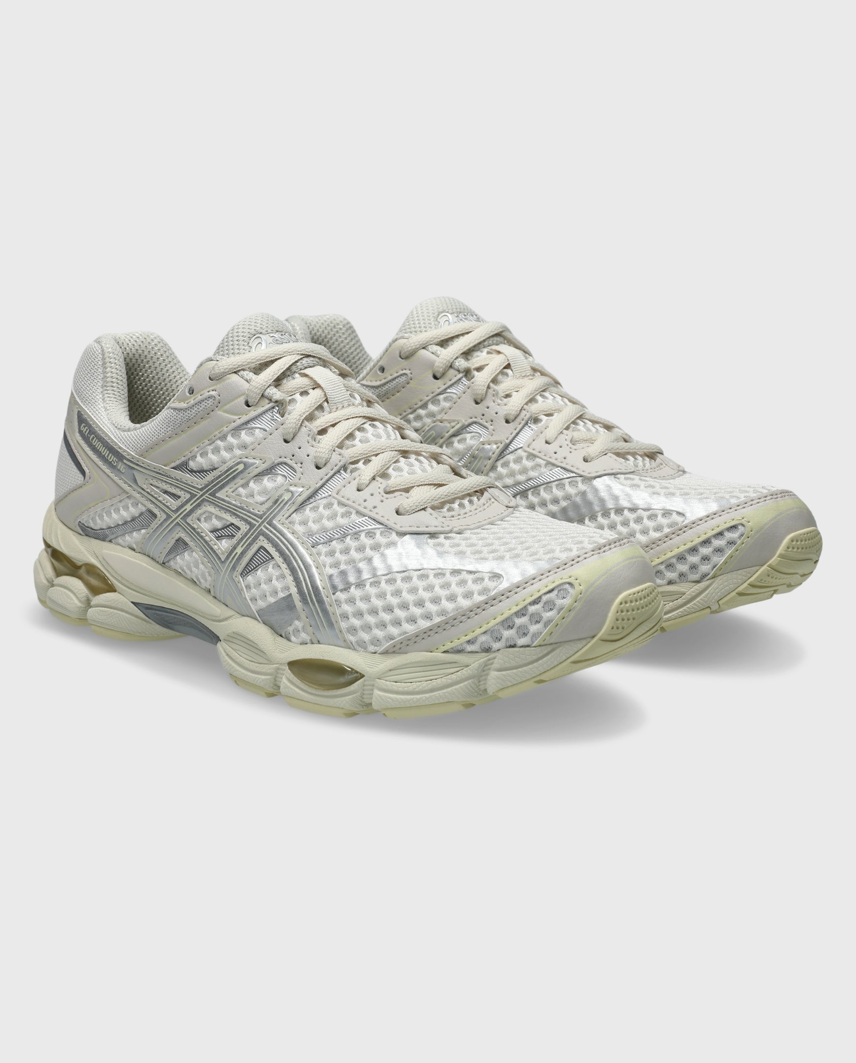 Asics hardloopschoen met crème veters, zilveren mesh-bovenwerk en dempende zool.