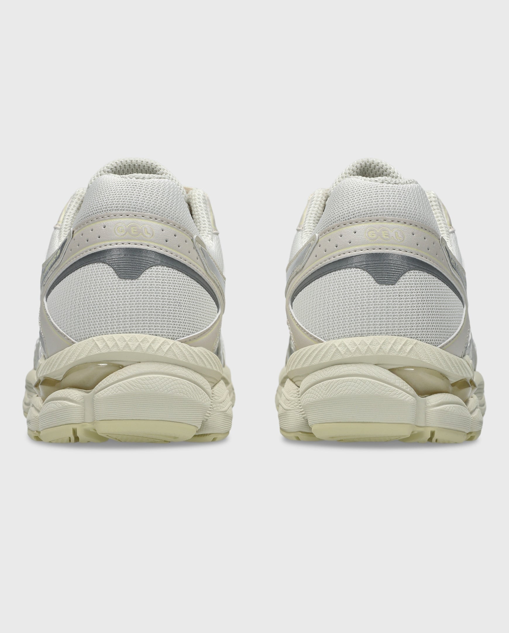 Asics hardloopschoenen met achterzijde in crème en lichtgele, geprofileerde zool.