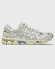 Asics hardloopschoen met crème mesh en zilveren overlays, zijaanzicht.