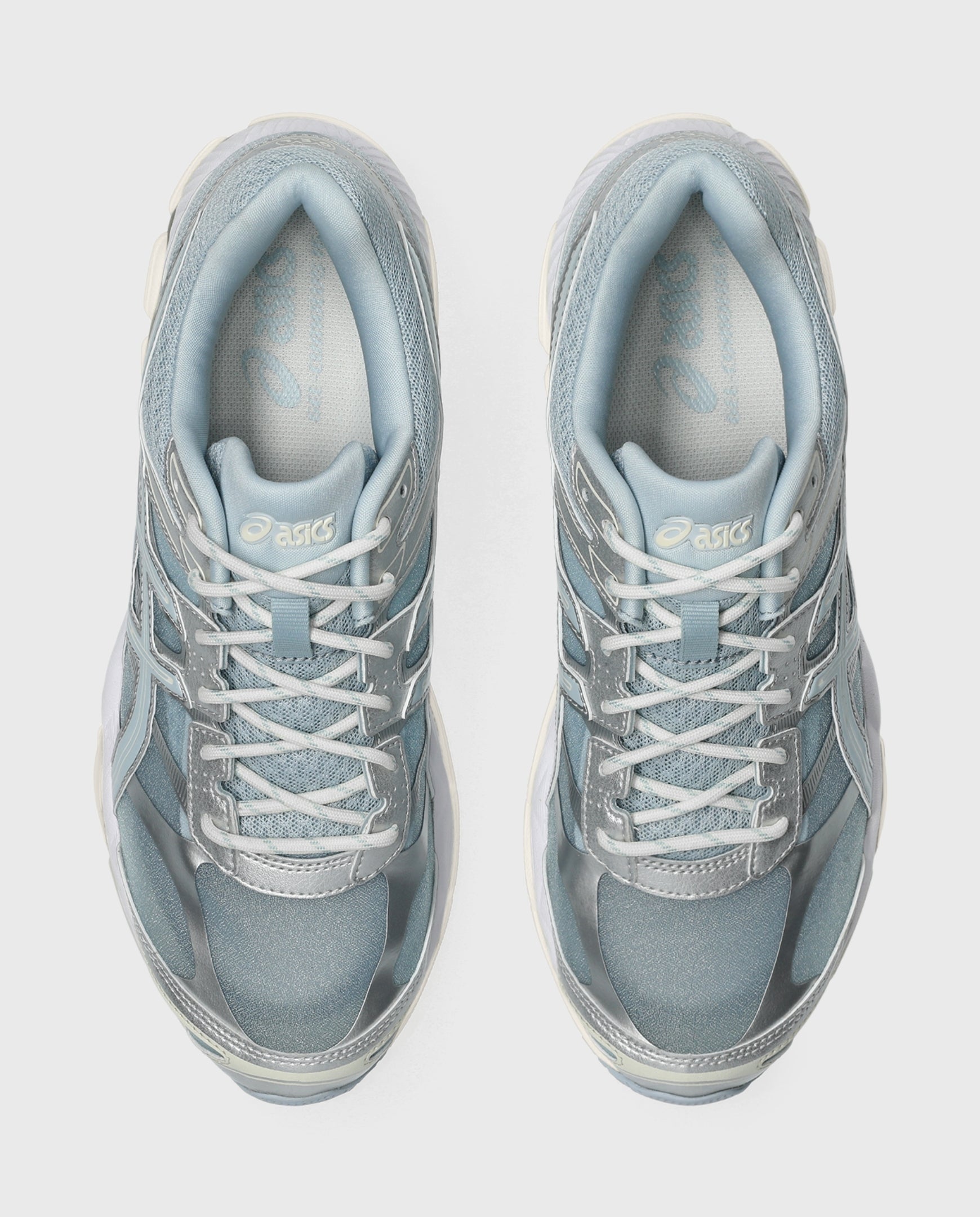 Asics hardloopschoen paar met lichtblauwe mesh-bovenkant en witte veters.