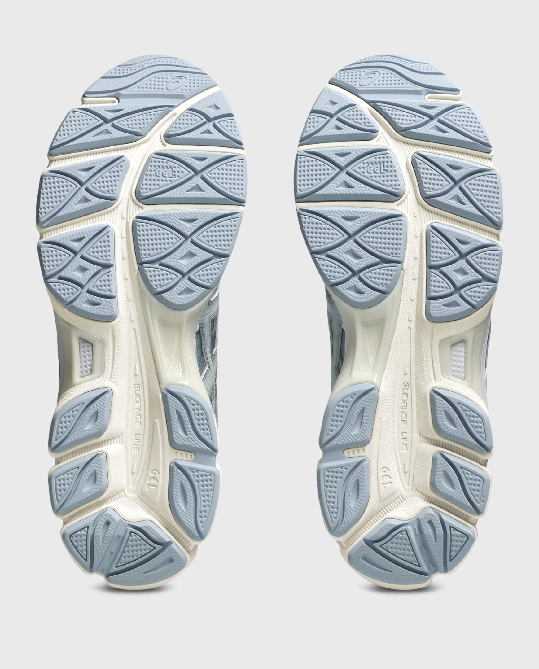 Asics hardloopschoen buitenzool met blauwgrijze noppen en witte middenzool.
