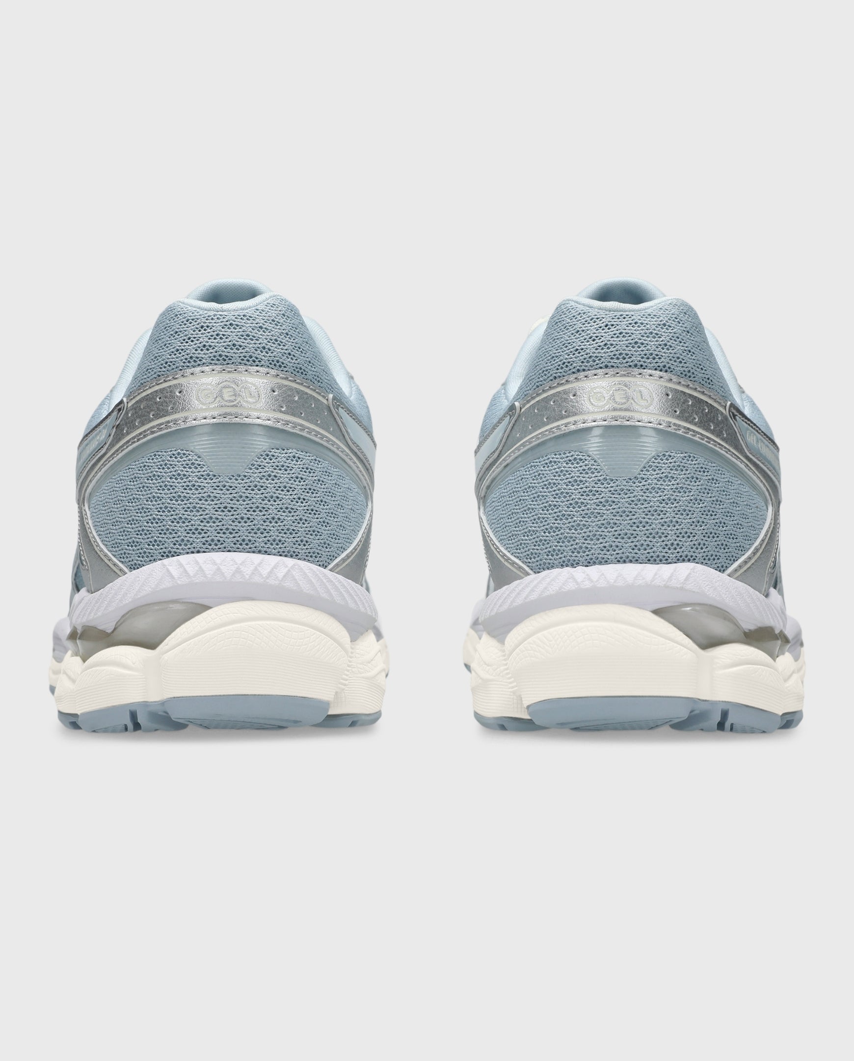 Asics hardloopschoen achteraanzicht met lichtblauwe stoffen hiel en gebogen zool.