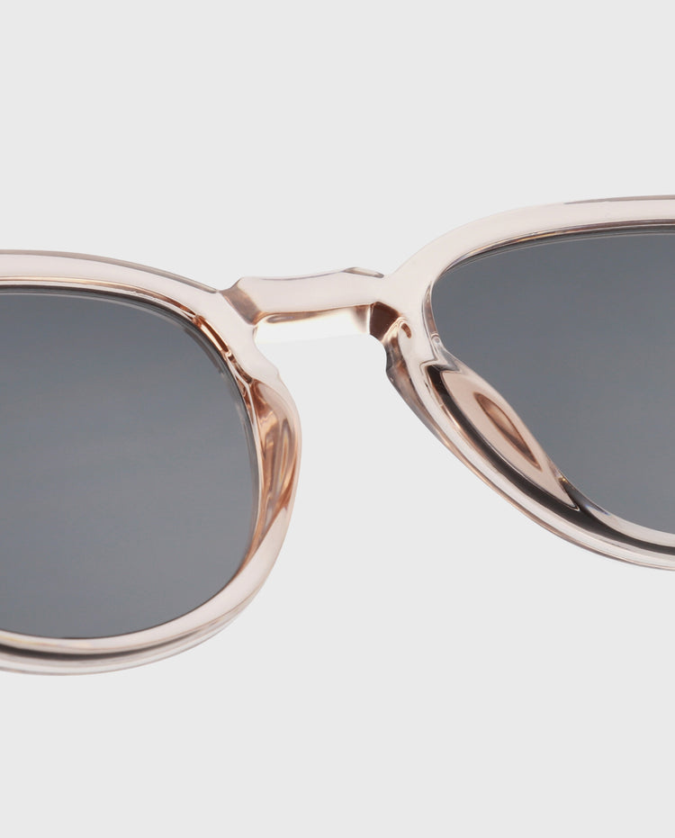 Zonnebril detail: roze-gouden rand en donkere ovale lens