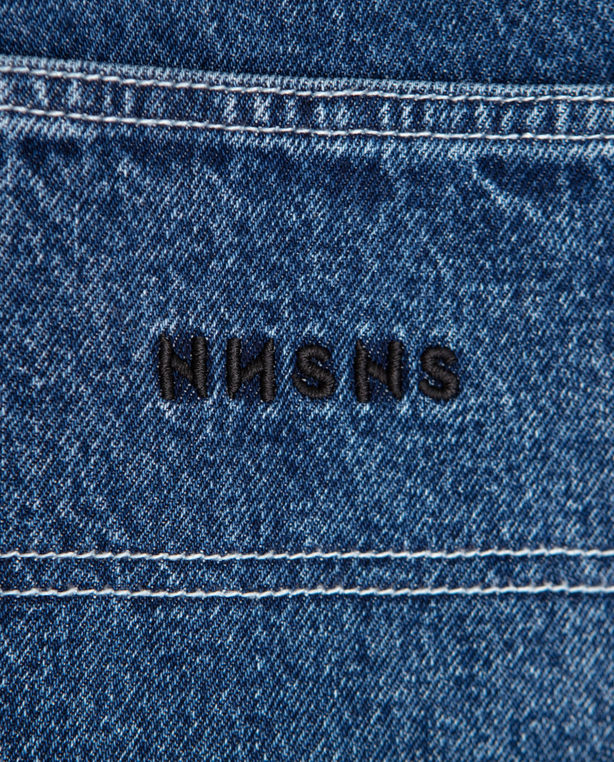 Donkerblauwe denim met zwarte geborduurde tekst op de tailleband