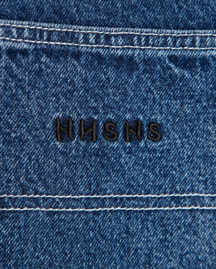 Donkerblauwe denim met zwarte geborduurde tekst op de tailleband