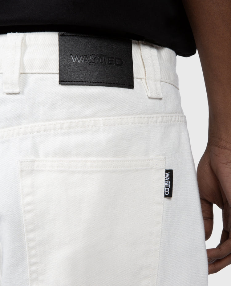 Casper broek off-white close-up: zwarte merketiket op achterzak en stiksels