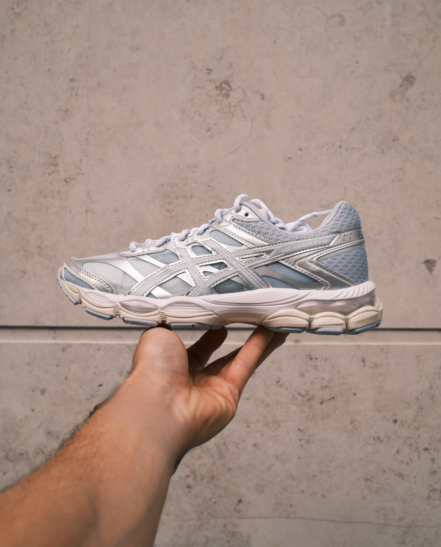 ASICS hardloopschoen in lichtgrijs met zilveren en roze accenten, laag model