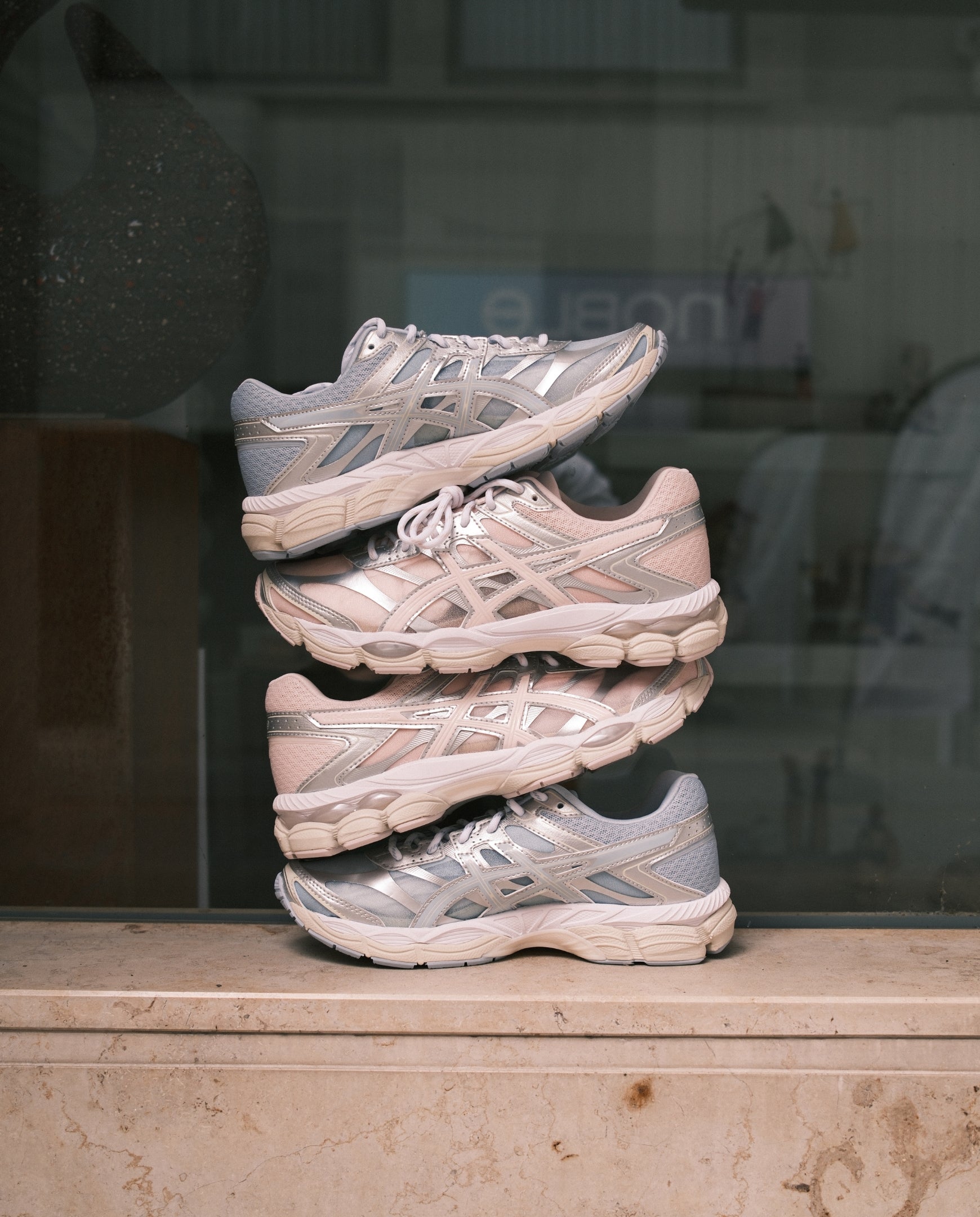 ASICS hardloopschoen lichtgrijs met roze en zilveren details, geschulpte rubberen zool