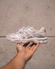 Roze Asics hardloopschoen met zilveren accenten en veters, zijkant zichtbaar