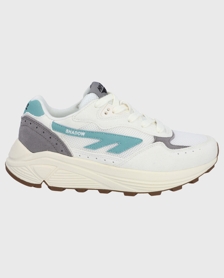 Sneaker schuin vooraanzicht: wit met turquoise logo, grijs detail en dikke zool.