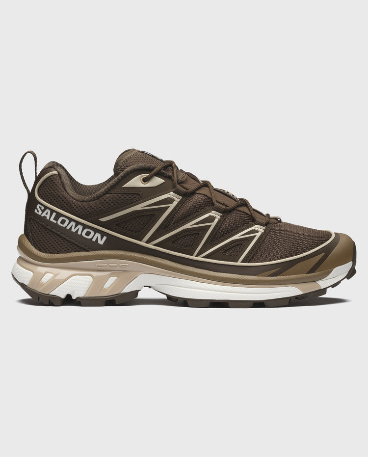 Salomon trail sneaker bruin met beige accenten, dynamisch profiel en witte tussenzool.