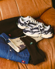 Paar donkerblauwe sneakers met witte mesh bovenkant en beige zool