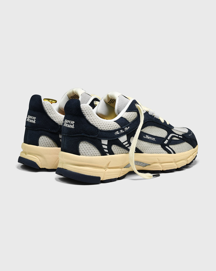 Donkerblauwe sneakers met witte inzet en beige zool, zijaanzicht