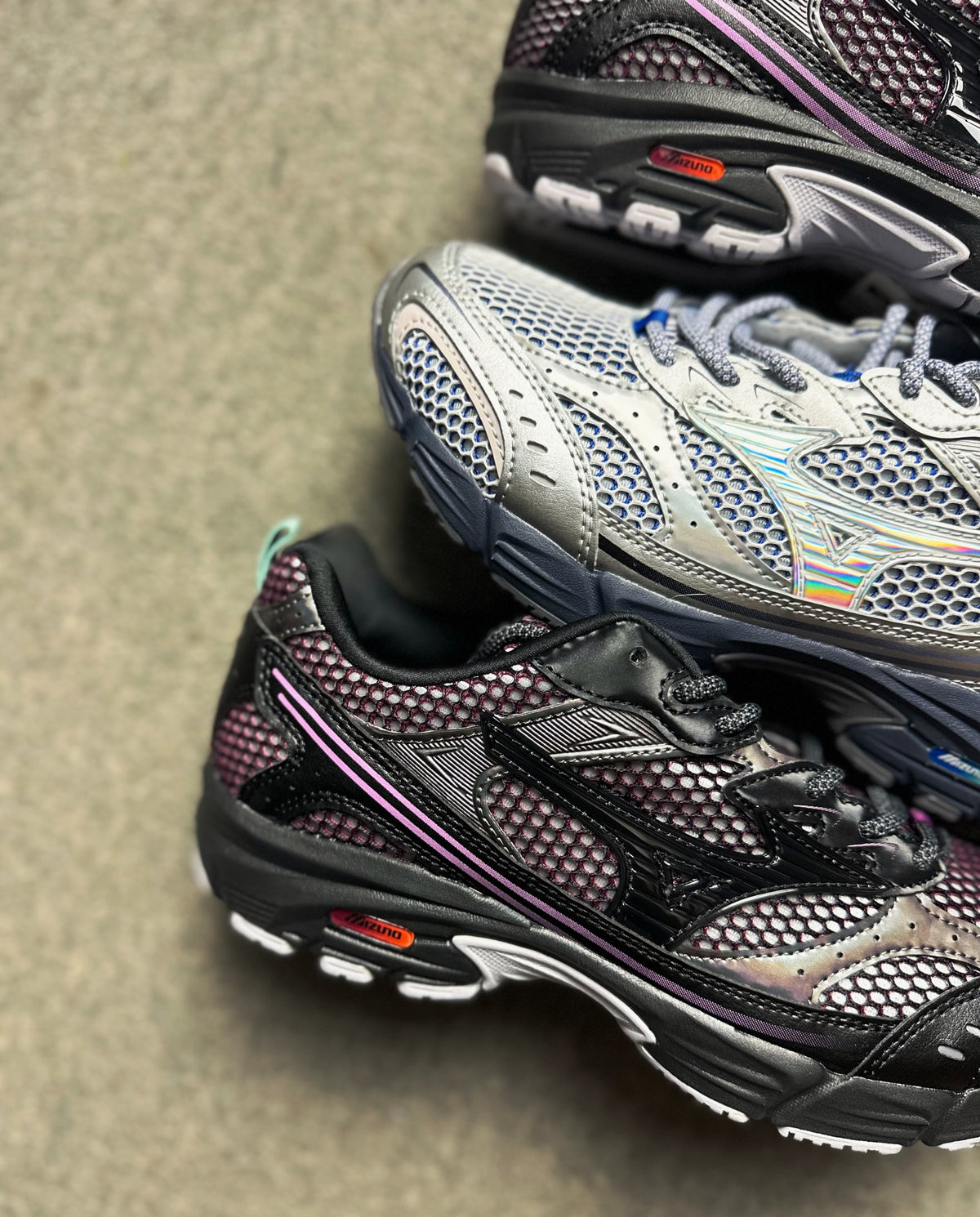 Mizuno hardloopschoenen met donkergrijs mesh en roze-paarse accenten, vetersluiting.