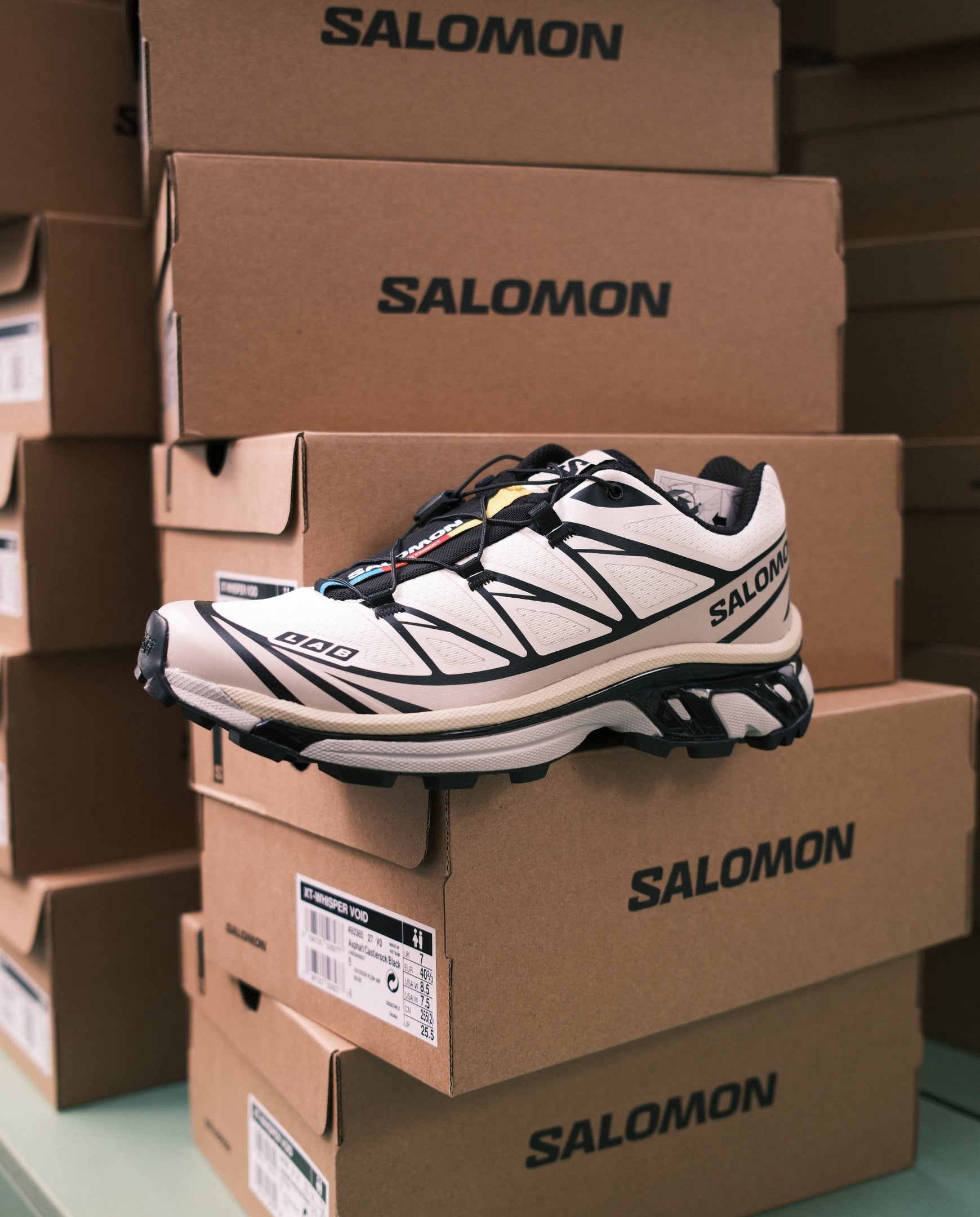 Salomon trailrunnerschoen met witte panelen, zwarte veters en contrasterende profielzool