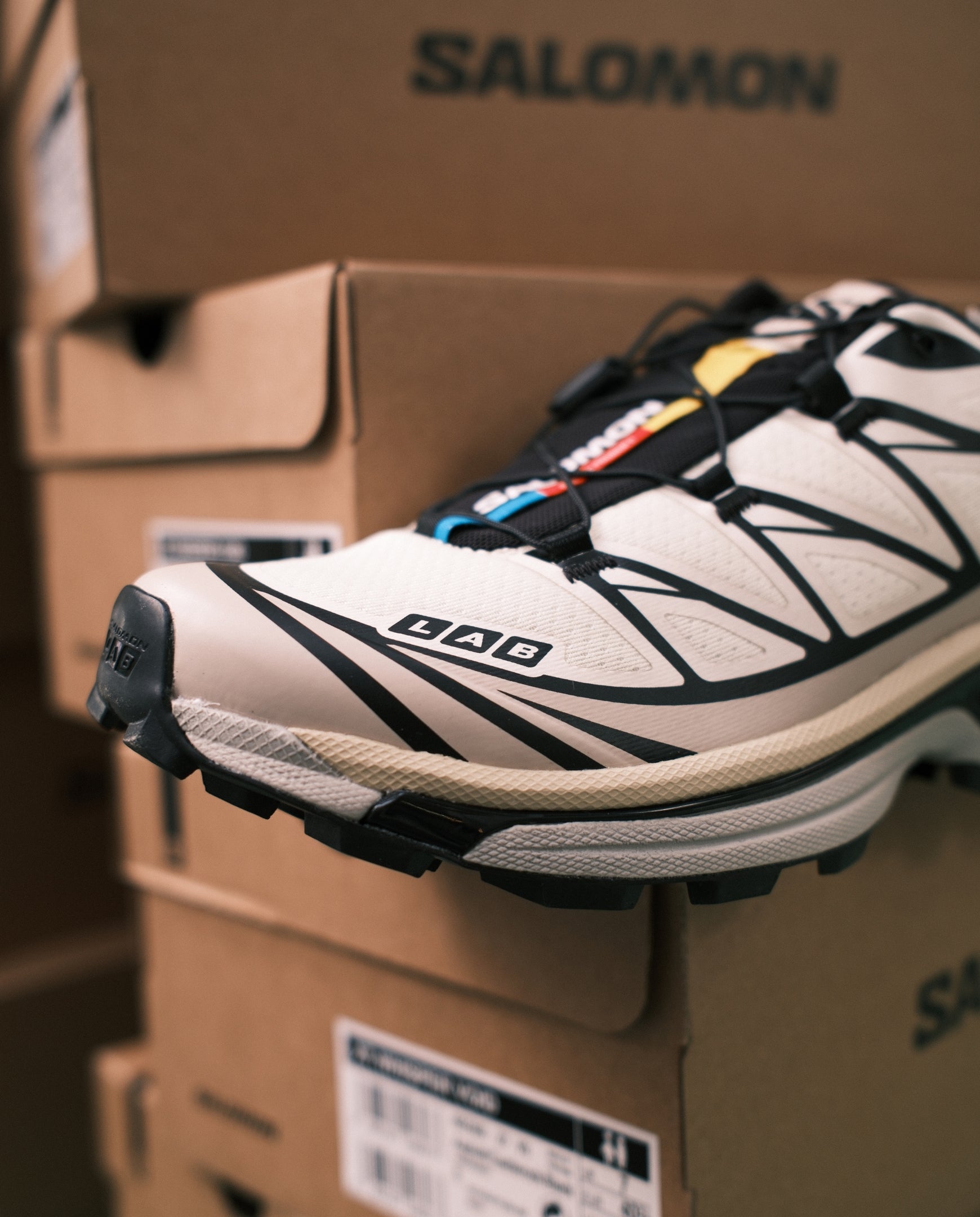 Salomon trailrunnerschoen met witte bovenkant, zwarte overlays en dikke profielzool