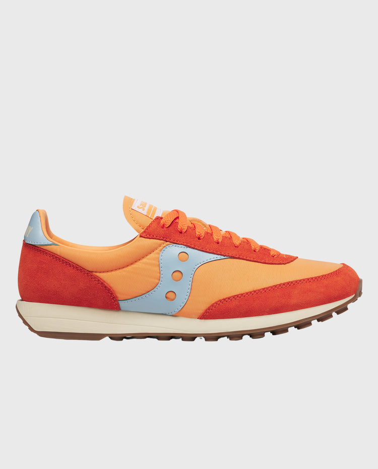 Zijaanzicht van oranje-rode sneaker met lichtbeige panelen, veters en rubberzool.