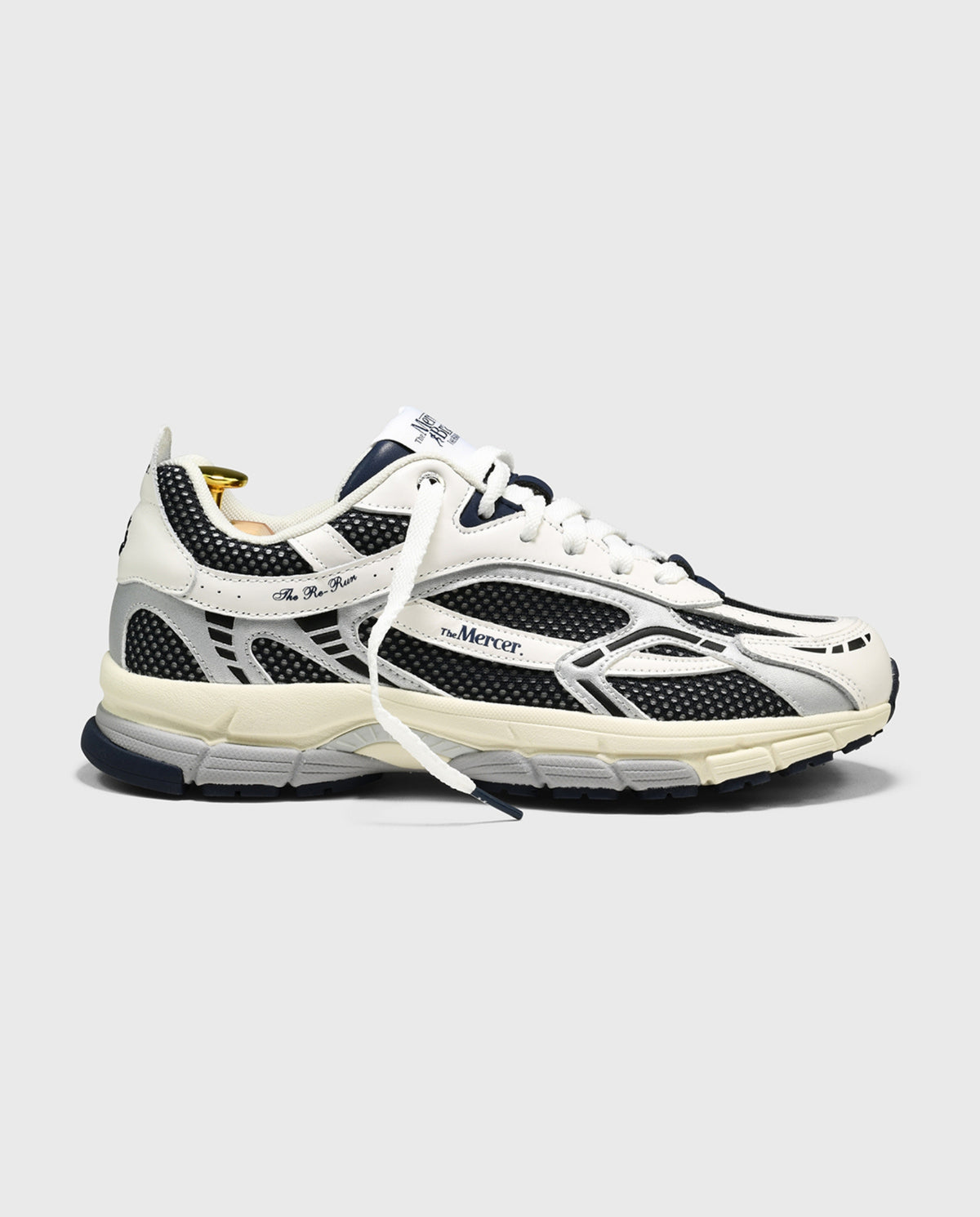 Witte sneaker met blauw-zwarte overlays, veters en sportieve tussenzool