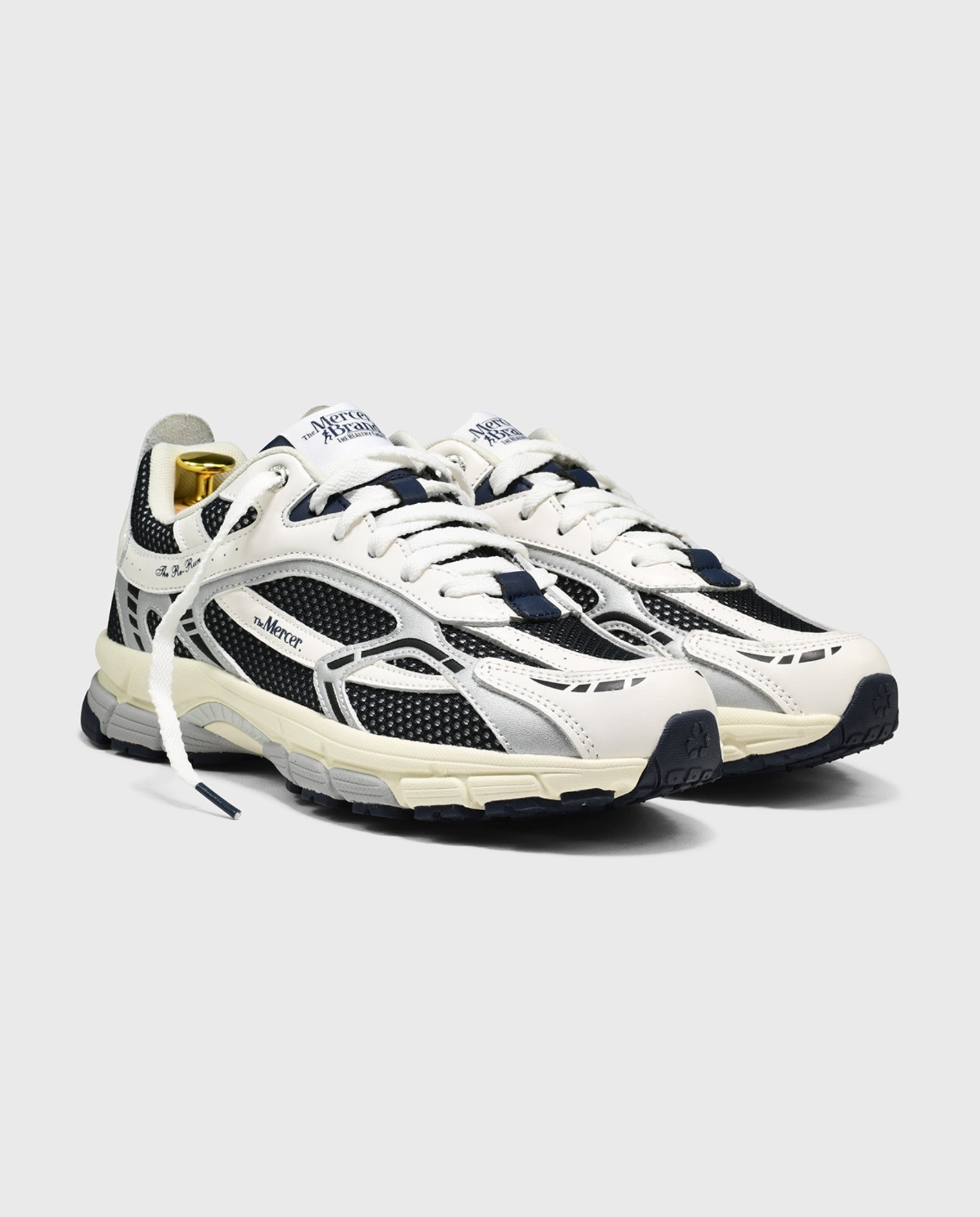 Witte hardloopsneakers met blauw-zwarte panelen, veters en dikke zool