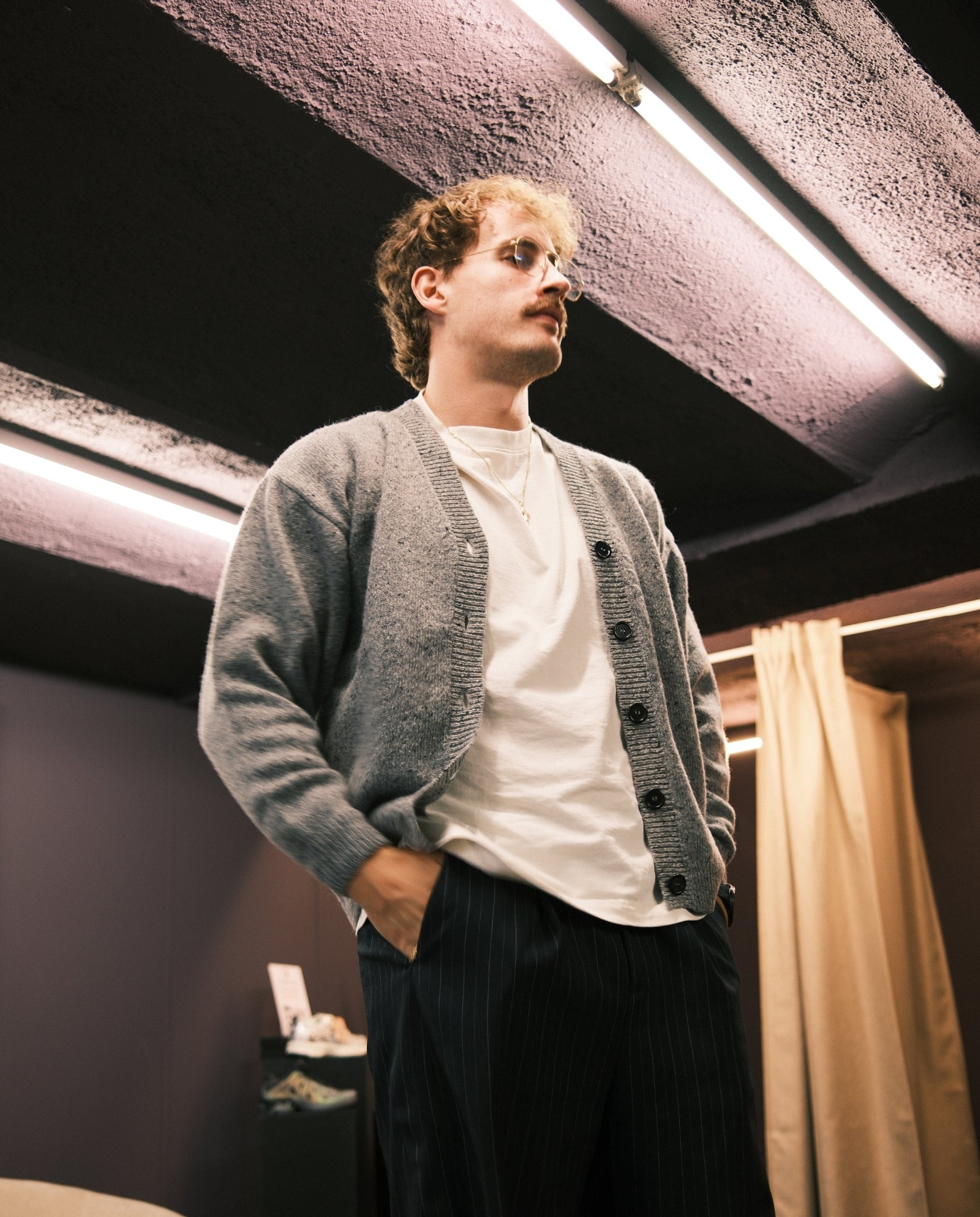Donkergrijze gebreide cardigan met knoopsluiting, gedragen over een wit shirt