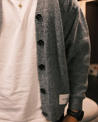 Donkergrijze gebreide cardigan met zwarte knopen en label aan de mouw