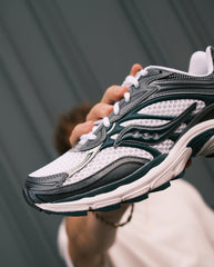 Saucony hardloopschoen met geperforeerde witte vlakken, zwarte en groene accenten, veters