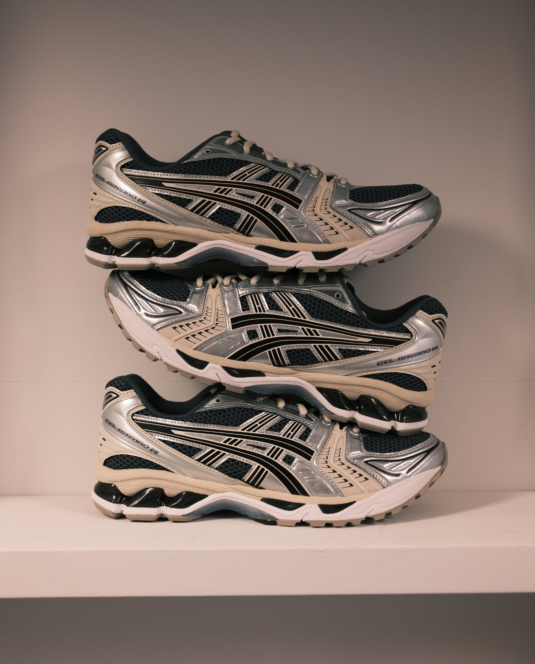 Asics Gel-Kayano 14 hardloopschoenen in grijs en zwart, paar op elkaar gestapeld