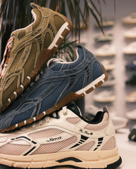 Close-up sneakers: suède zandkleur en donkerblauw, beige paar op achtergrond