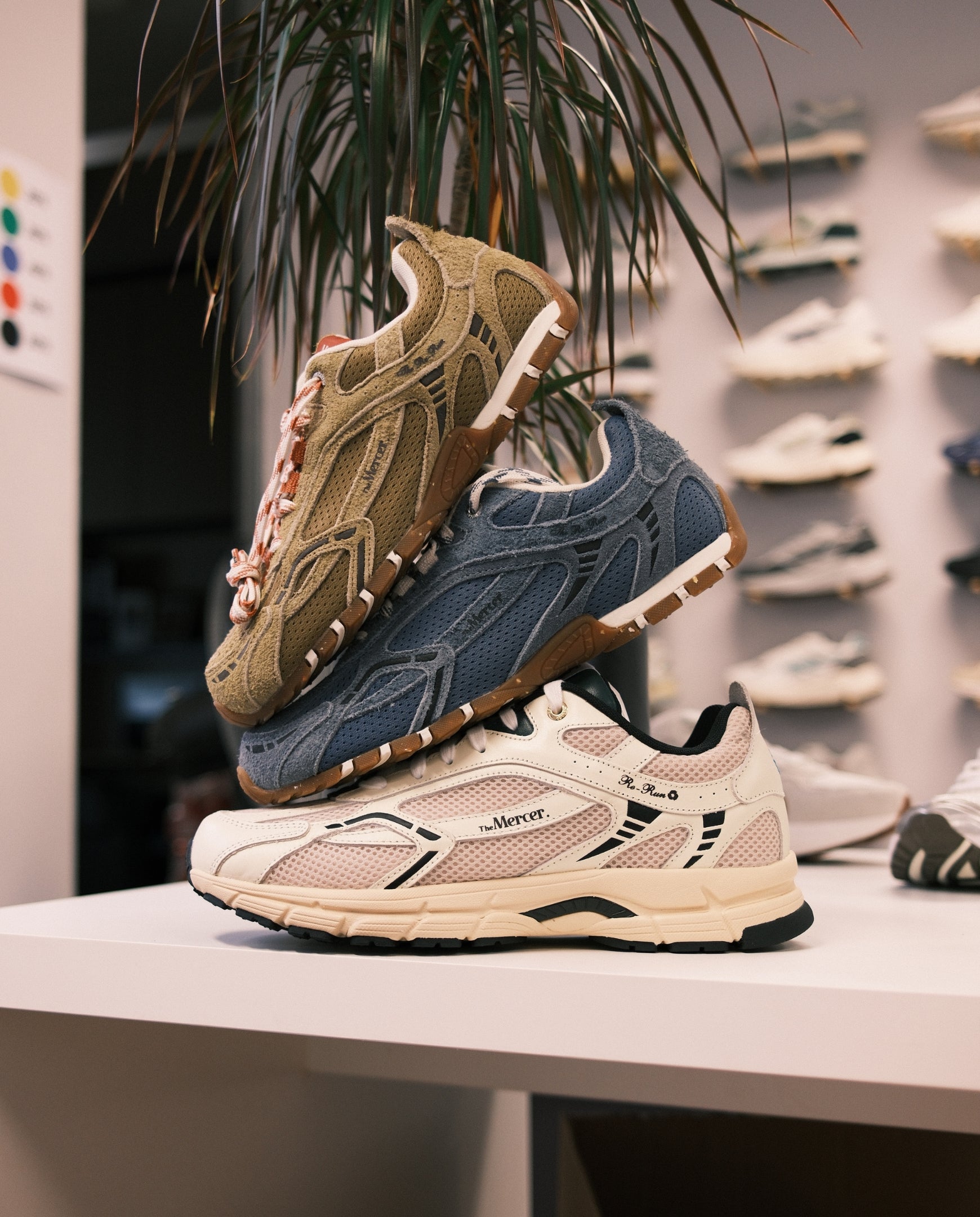 Sneakers op plank: suède zandkleur, blauw en beige met roze accenten