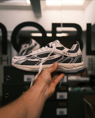 Lichtroze sneaker met zwarte mesh en witte veters