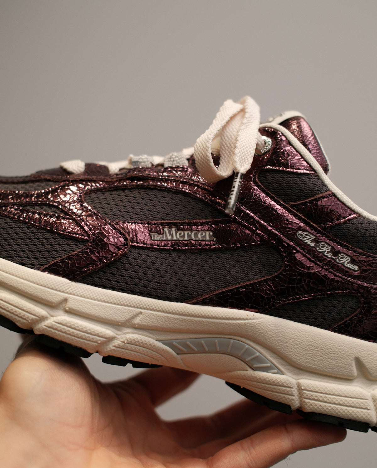 Donkerrode sneaker met gebarsten textuur, witte veters en crèmekleurige zool