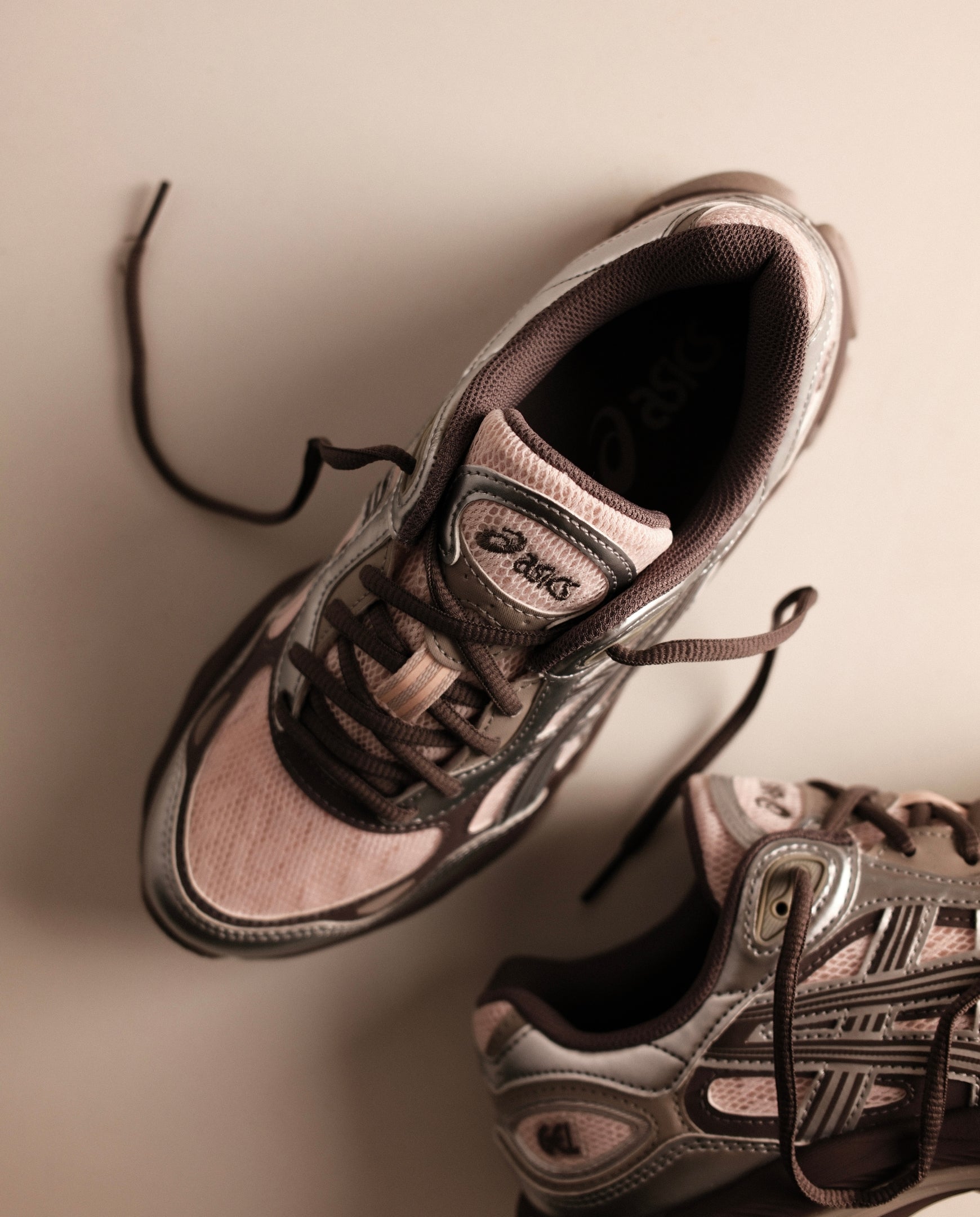 Roze en zilveren hardloopschoen met veters en zichtbare tong met label