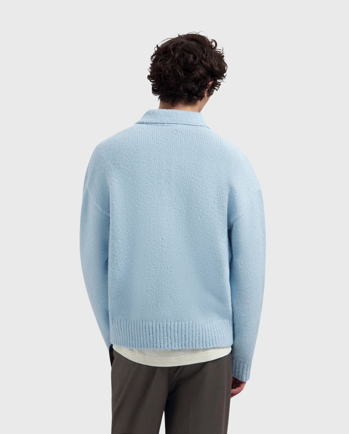 Blauwe gebreide polo achterkant met ronde boord en ribdetail aan de zoom