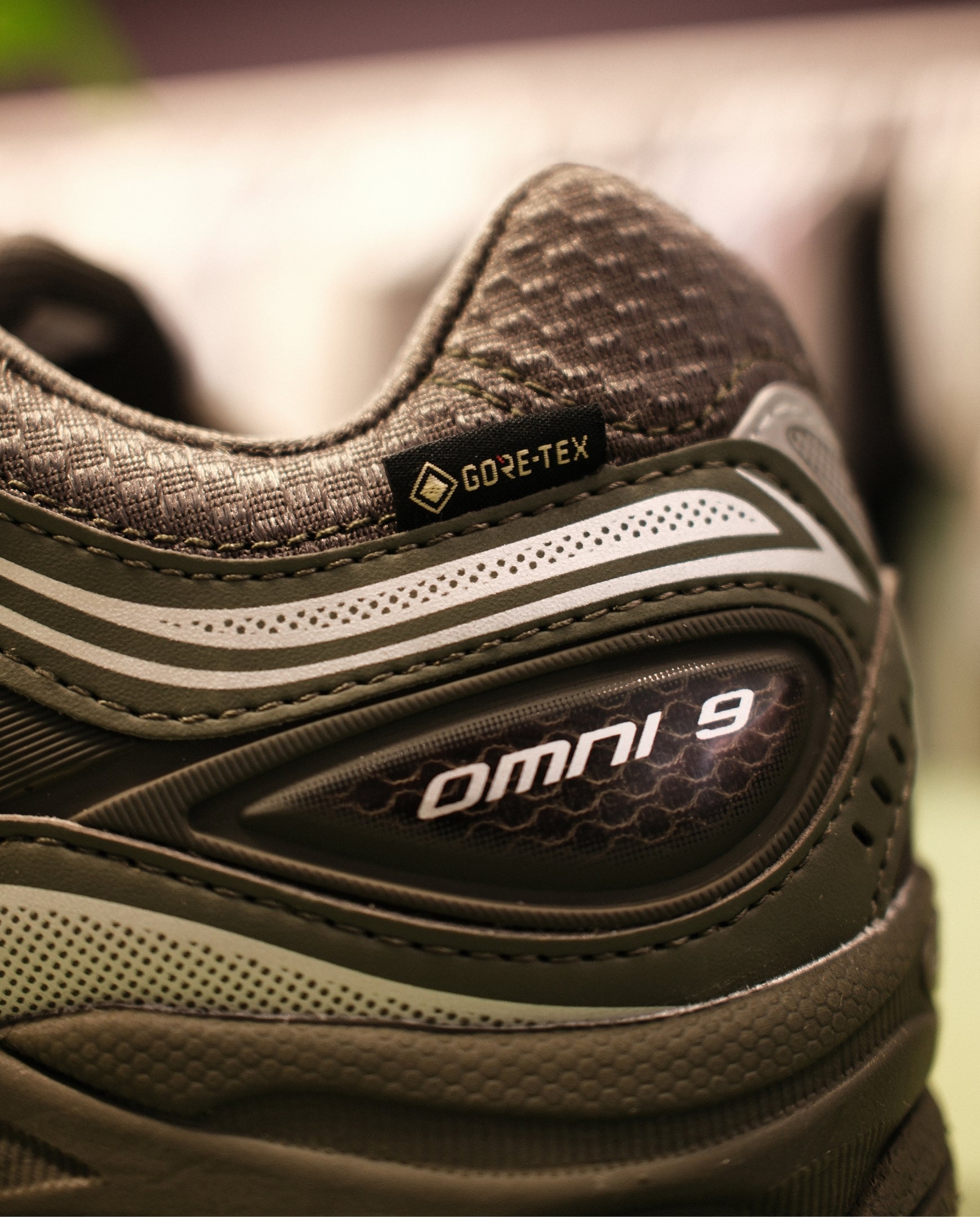 Saucony schoenen, GORE-TEX logo op hiel, donkerbruin met witte stiksels en Omni 9-badge