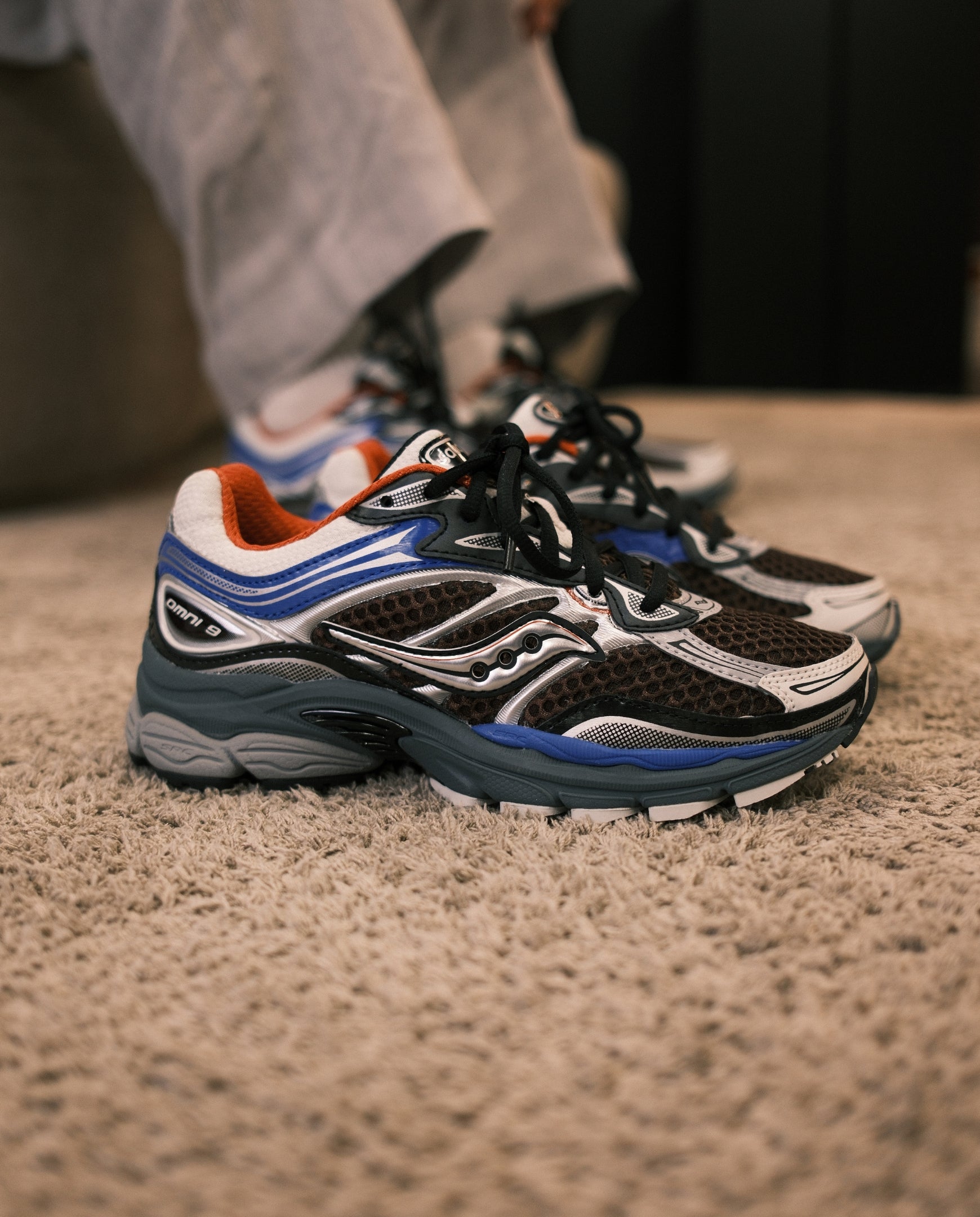 Saucony hardloopschoenen wit met zwart mesh, blauwe zijkant en oranje kraag