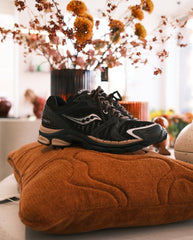 Saucony hardloopschoenen met zwarte mesh bovenwerk en witte sierstrepen, veters en lichtroze zool